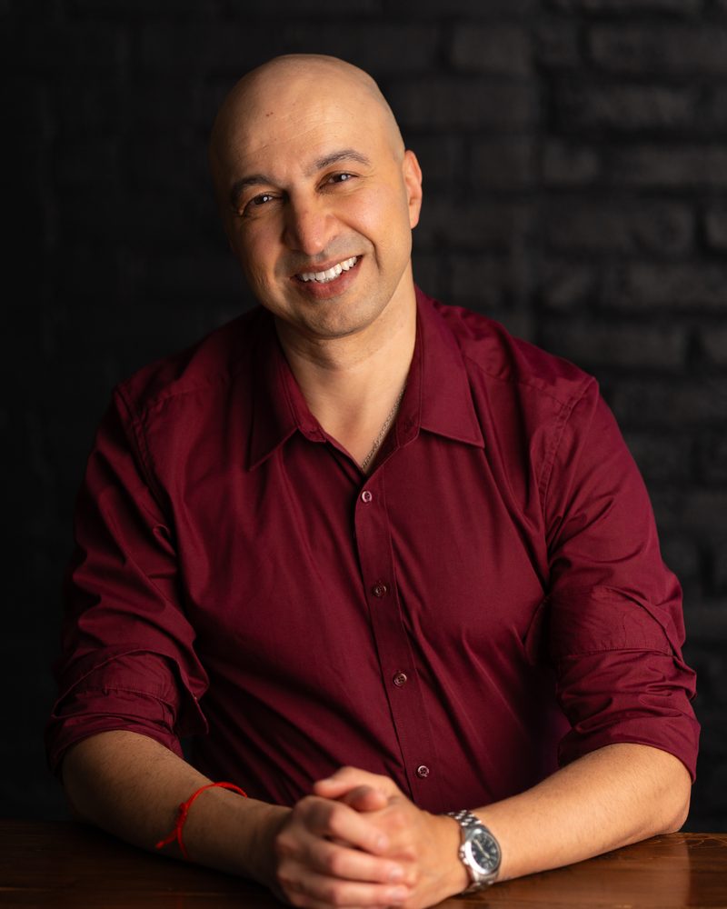 Hicham Souilmi, SEO and AI search consultant, smiling, seated at a wooden table
